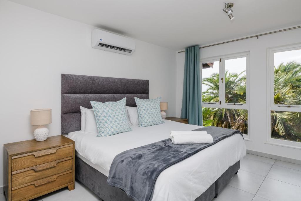 Un dormitorio con una cama grande y una ventana en San Lameer Villa 2519 - Bachelor Studio - 2 pax - San Lameer Rental Agency, en Southbroom