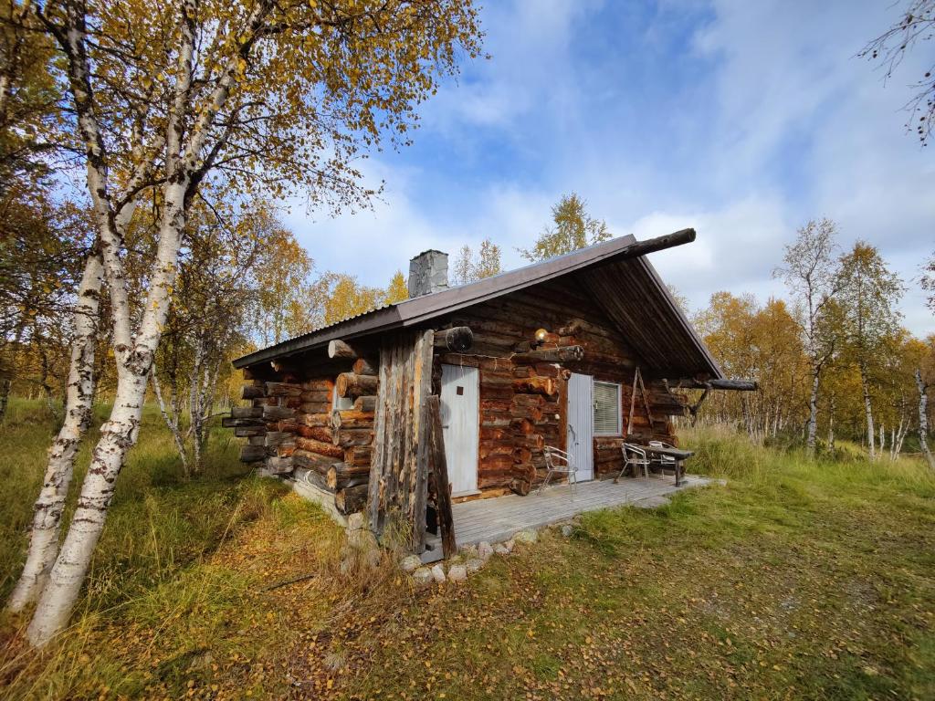 una cabaña de madera en medio de un campo en Villa Lavijoki en Karesuvanto