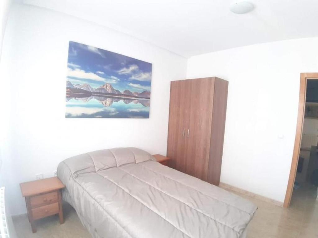 a bedroom with a bed and a painting on the wall at Apartamento Zig Zag in Murcia