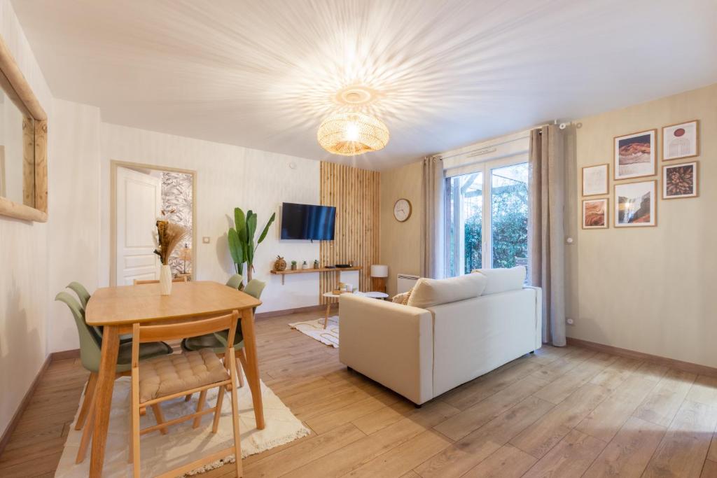 Una sala de estar con un sofá blanco y una mesa. en La Bohème, en Montévrain