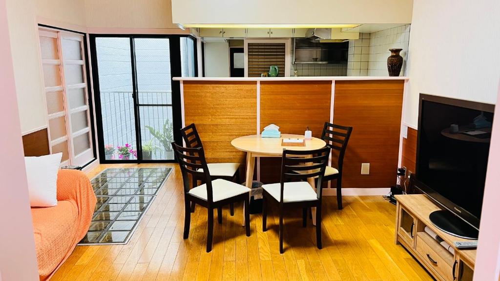 uma cozinha e sala de jantar com mesa e cadeiras em 田町ハウス em Takamatsu