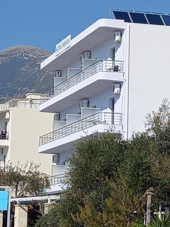 un edificio blanco con balcones en un lateral en Hotel Prinos, en Himare