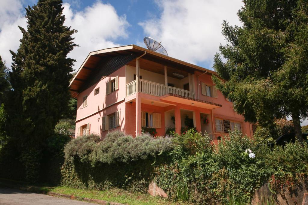an orange building with a balcony on top of it at Pousada Sino dos Ventos in Campos do Jordão