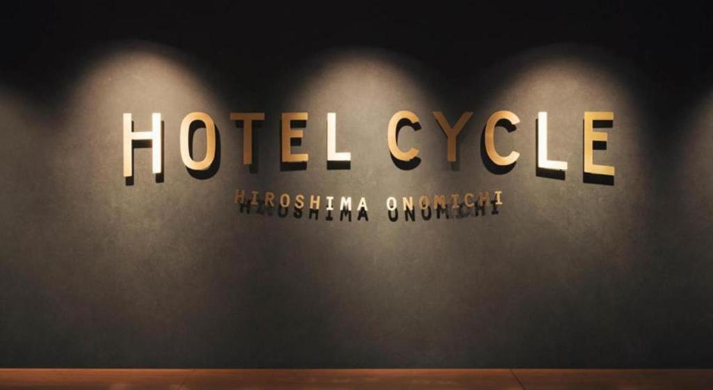 um sinal de bicicleta de hotel numa parede num quarto em Hotel Cycle em Onomichi