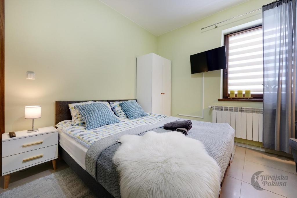 a bedroom with a large bed with blue and white pillows at Jurajska Pokusa in Kroczyce