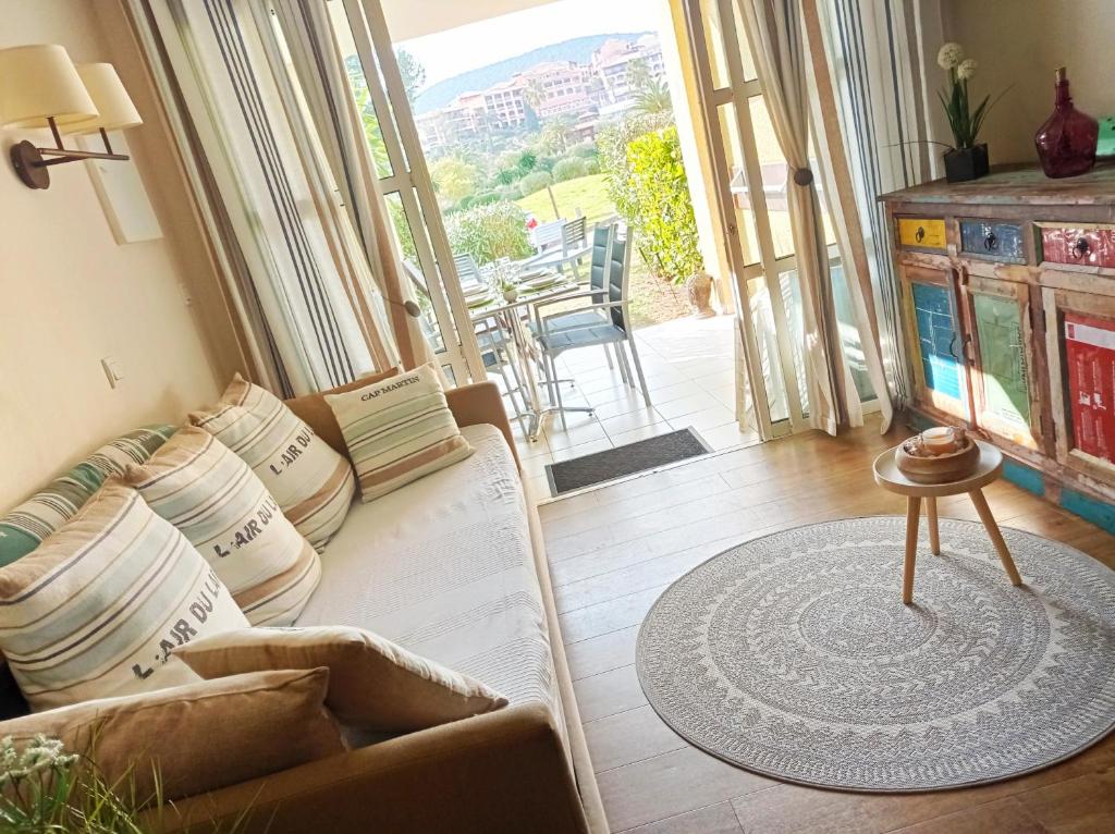 a living room with a couch and a large window at Cap Esterel Rez de jardin D2 in Saint-Raphaël