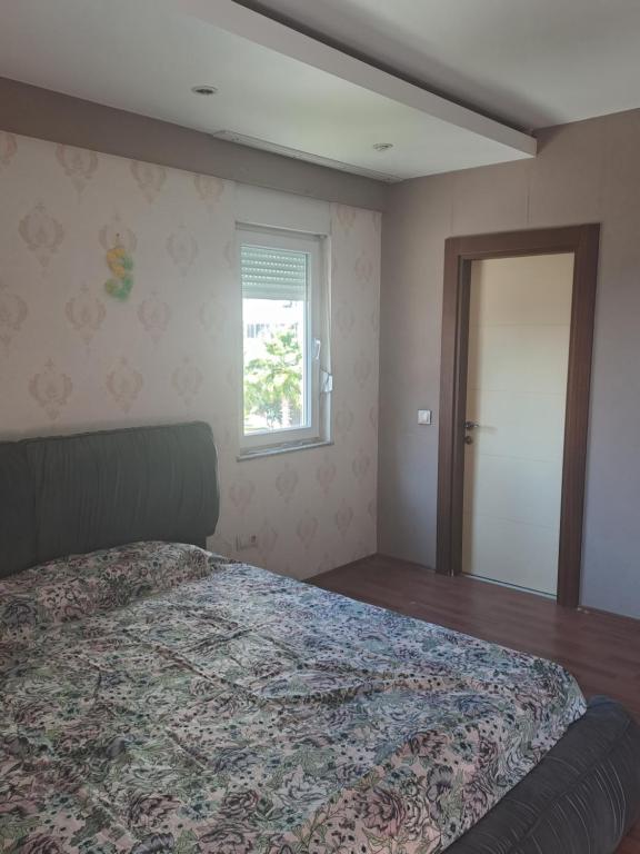 a bedroom with a large bed and a window at 3-1квартира с бассейном в 2,5 км от моря in Altınkum