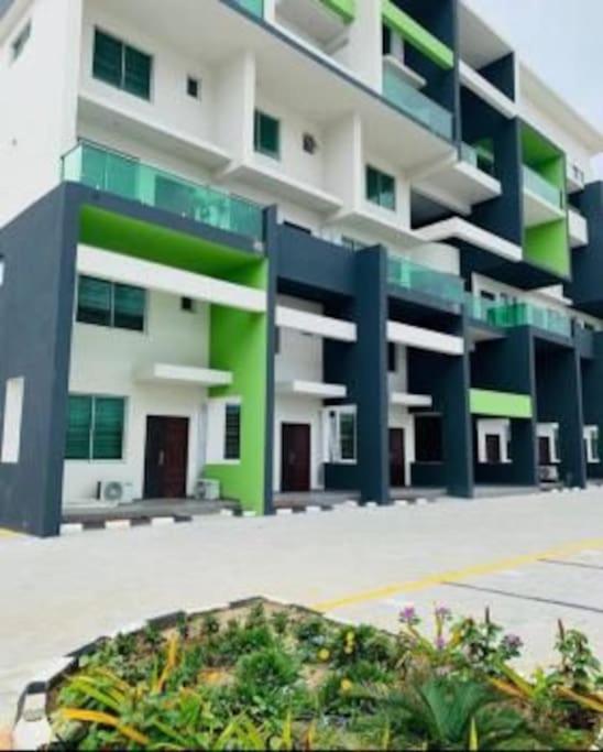 a large apartment building with green and white at Lovely 2 bedroom in ikate in Lekki