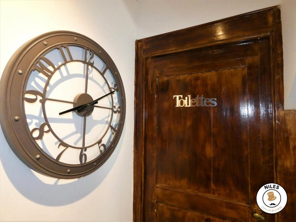 a clock on a wall next to a door at La Caze Paloise ~ Atypique ~ 100% Fonctionnel in Pau
