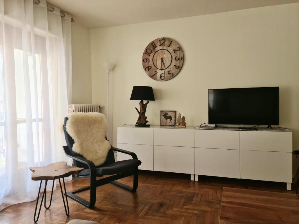 ein Wohnzimmer mit einem Stuhl und einem TV in der Unterkunft Appartamento Mont Fleury in Valtournenche