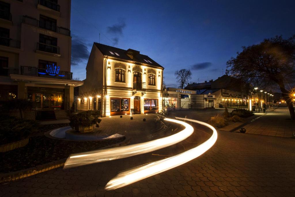 a building with lights on a street at night at Zuckmann Villa in Piešťany