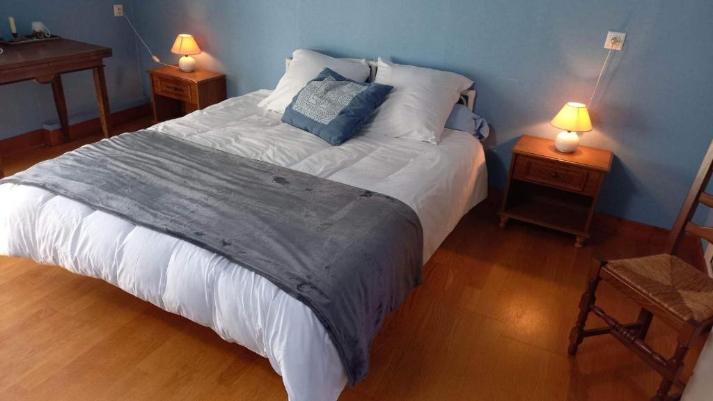 ein Schlafzimmer mit einem großen Bett mit zwei Nachttischen in der Unterkunft Le Clos du Merry in Joux-la-Ville