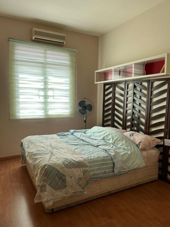 una camera con letto e finestra con ventilatore di Mutiara Soul Garden PROMO-DEAL 3RLanded Stays a Puchong