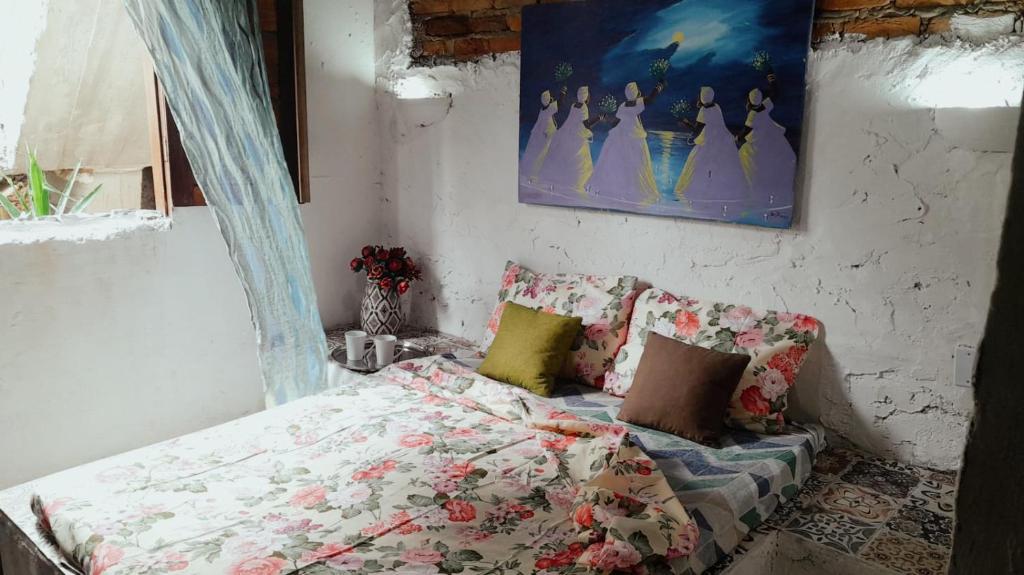 een slaapkamer met een bed en een schilderij aan de muur bij Pousada Rainha das Águas in Ilhéus