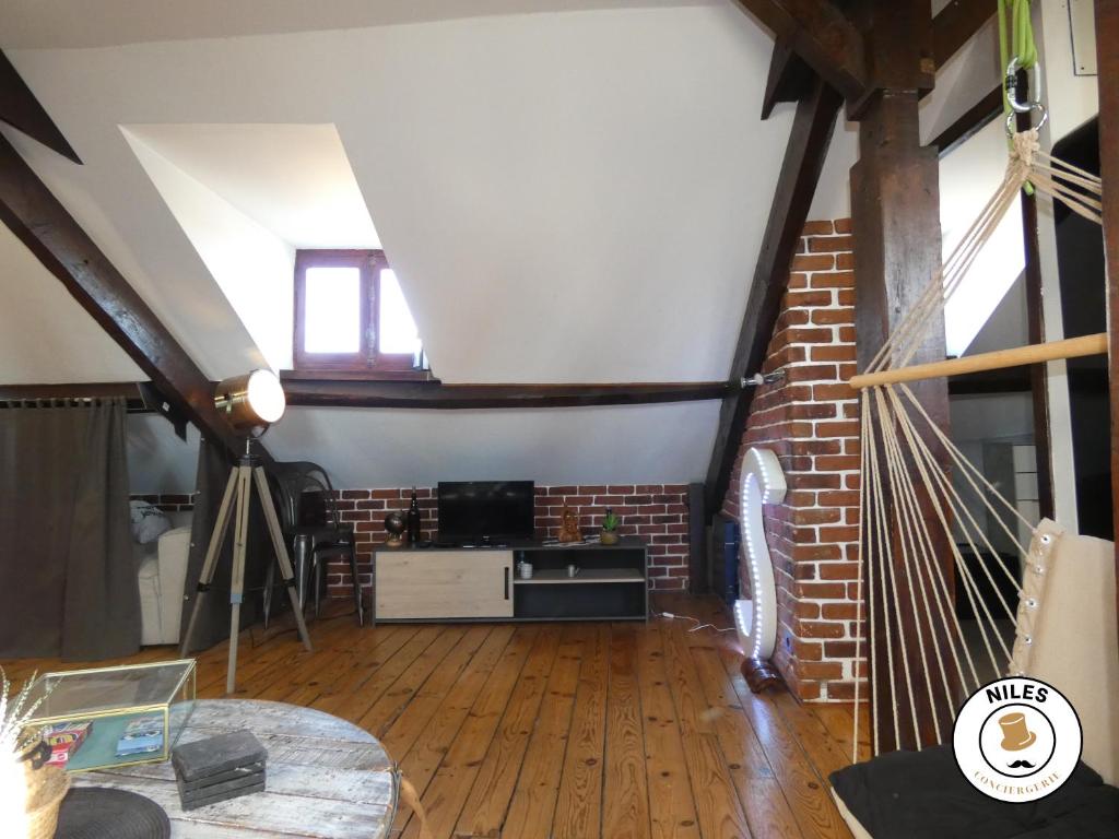 a living room with a brick wall and a table at La Caze Paloise ~ Atypique ~ 100% Fonctionnel in Pau