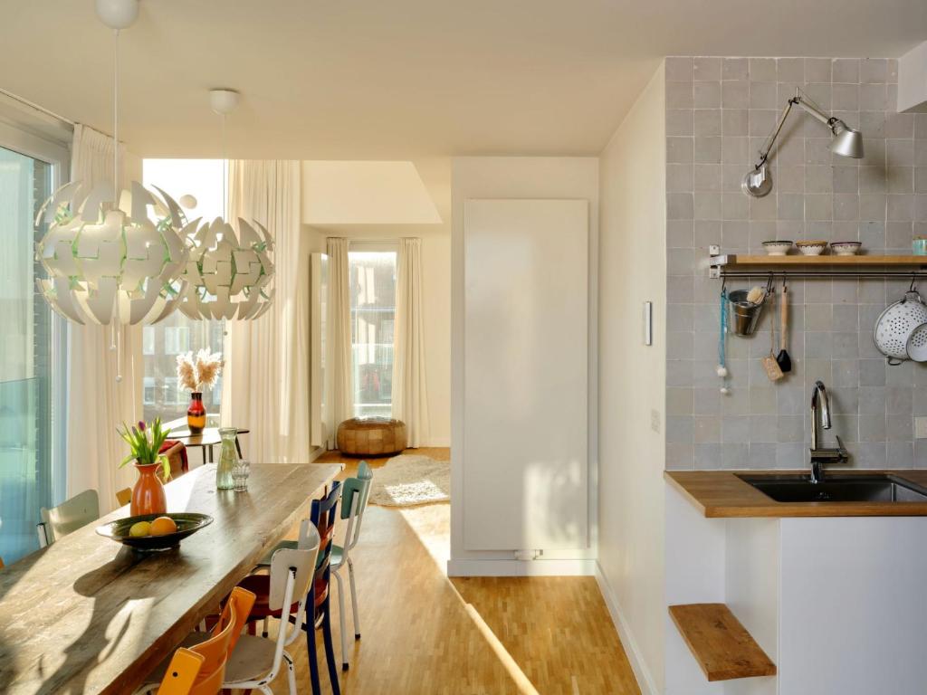 Una cocina y un comedor con mesa y sillas. en Stijlvolle en lichtrijke design penthouse met prachtig uitzicht te Wenduine, en De Haan