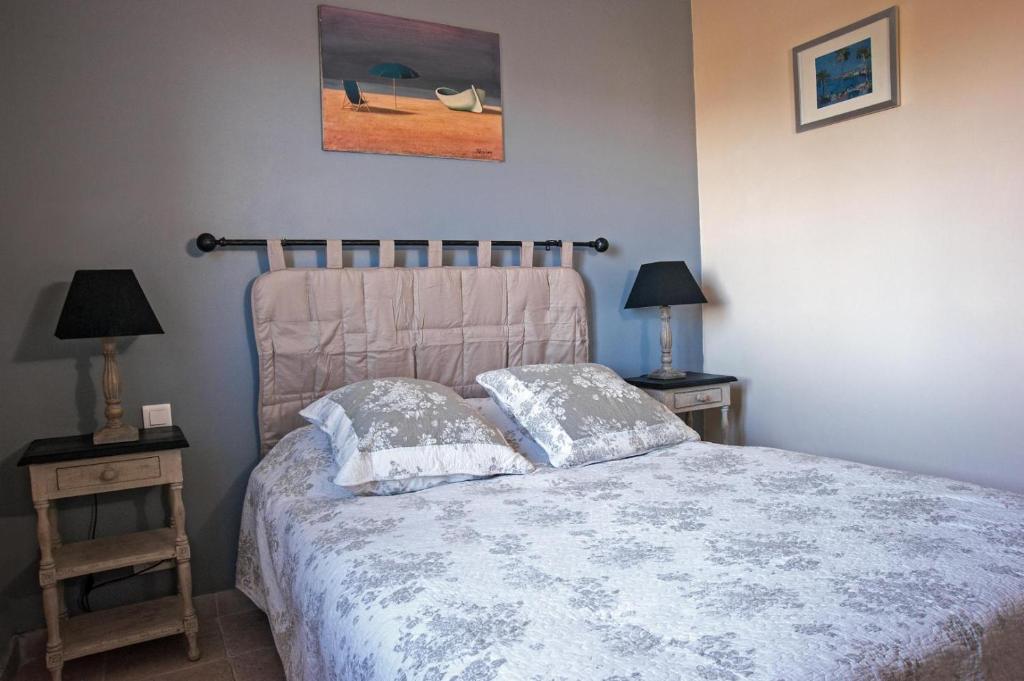 une chambre avec un lit avec deux tables de nuit et deux lampes dans l'établissement La maison de nathalie gite romeo g2483, à Les Mayons