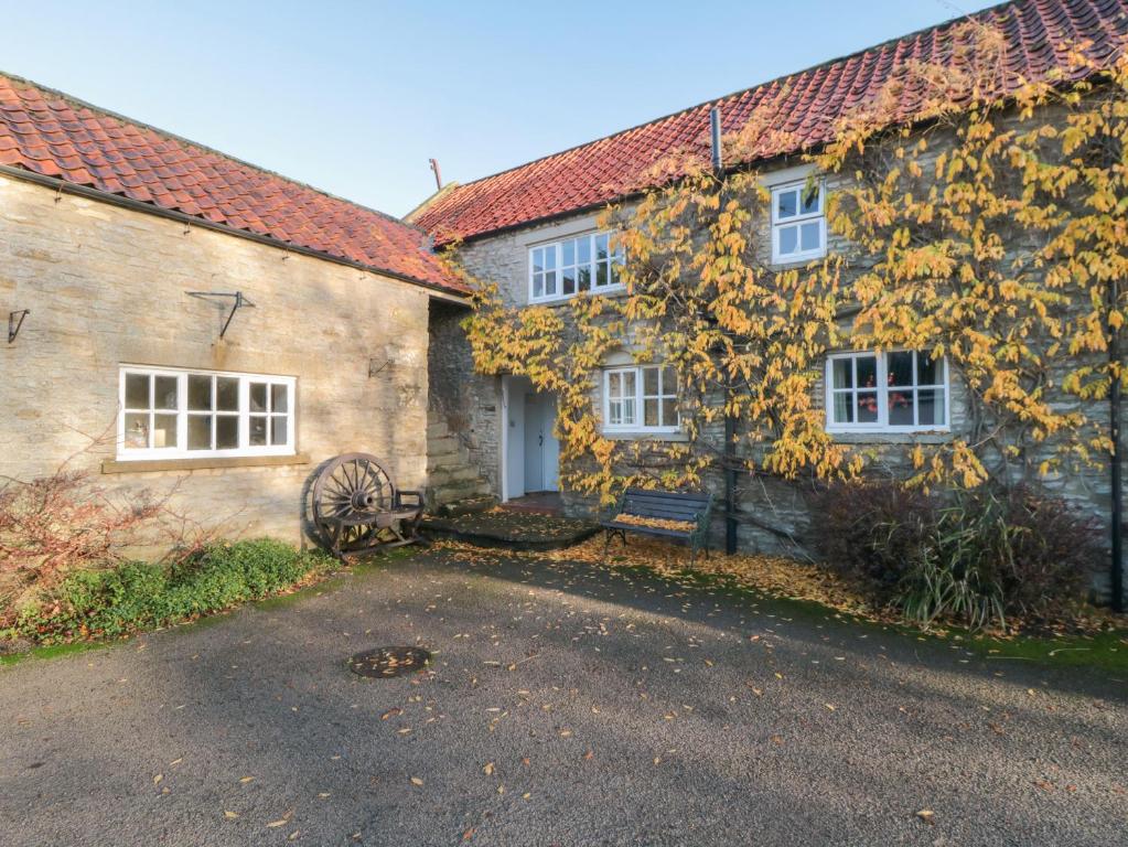 an old stone house with yellow leaves on it at Big Cottage in York