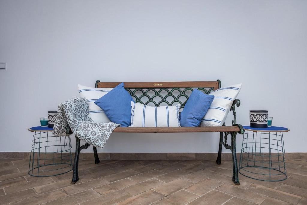 um banco com almofadas azuis e brancas em Cabo de Sagres -2 bedroom apartment em Sagres
