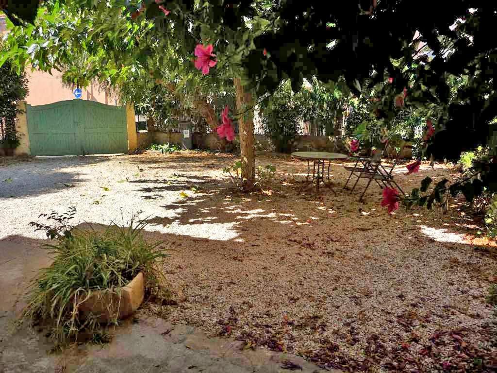 une cour avec une table de pique-nique et un arbre dans l'établissement Gîte Le Gite Sanary-sur-mer centre ville., à Sanary-sur-Mer