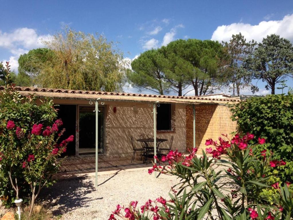 une petite maison avec des fleurs roses devant elle dans l'établissement La cigale rouge a callian, à Callian