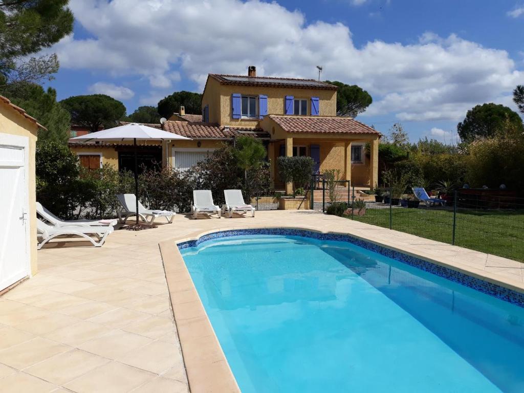 une villa avec piscine devant une maison dans l'établissement Mas longo mai avec piscine, à Vidauban
