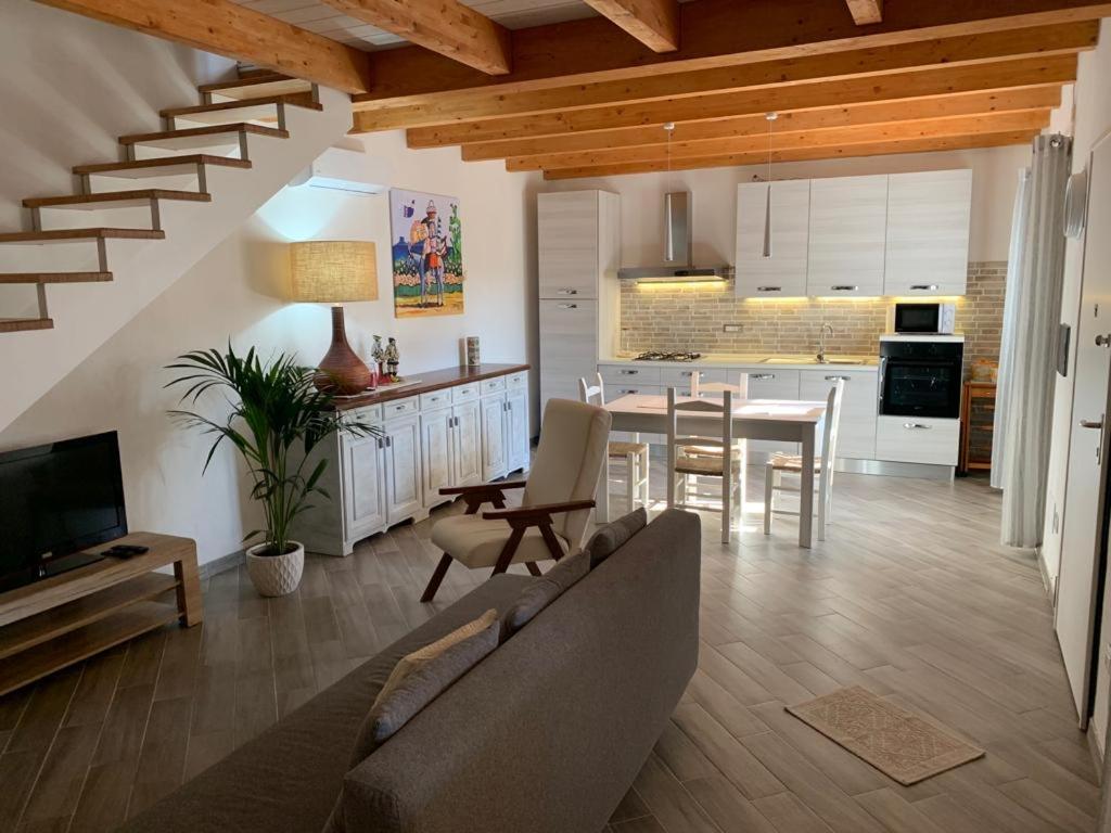 uma sala de estar e cozinha com um sofá e uma mesa em Domu Quesada em San Giovanni Suergiu