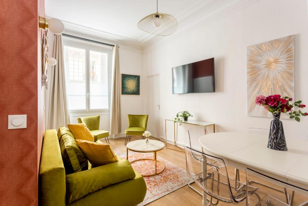 ein Wohnzimmer mit einem Sofa und einem Tisch in der Unterkunft Cosy 3 bedroom and 2 Bathroom - Opera in Paris