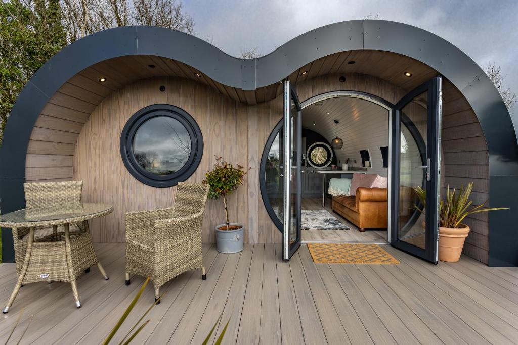 a circular room with a bed and a table and chairs at The Lodge @Quarrywood in Tenby