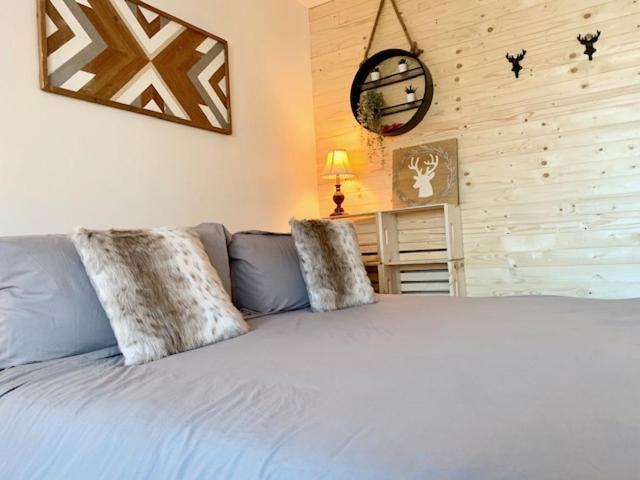 um quarto com uma cama com duas almofadas em Loft LèSKImo, lit king, sauna, piscine et montagne em Saint-Férréol-les-Neiges