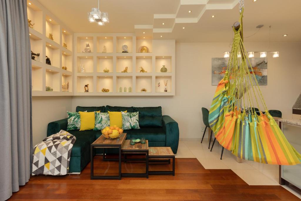 a living room with a green couch and a table at Mokotów Unique & Pet-Friendly Apartment by Renters in Warsaw