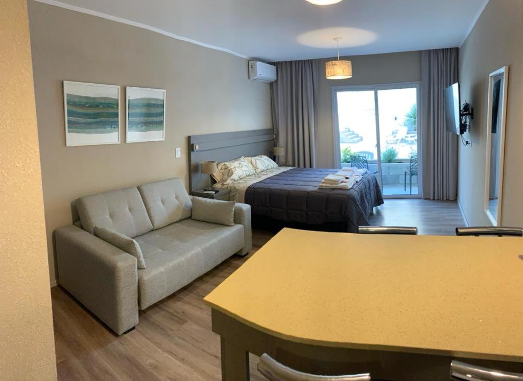 Habitación de hotel con cama, sofá y mesa en Apart Casa De Playa Premium en Necochea