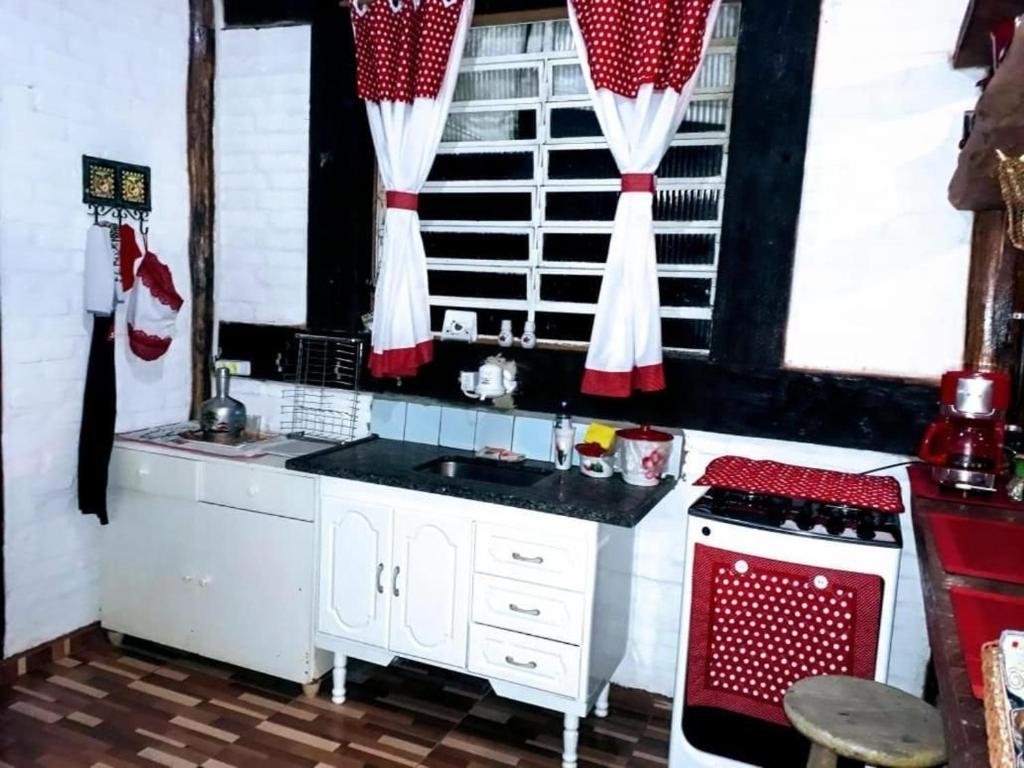 A kitchen or kitchenette at Chalé Rustic House 2 Com hidromassagem