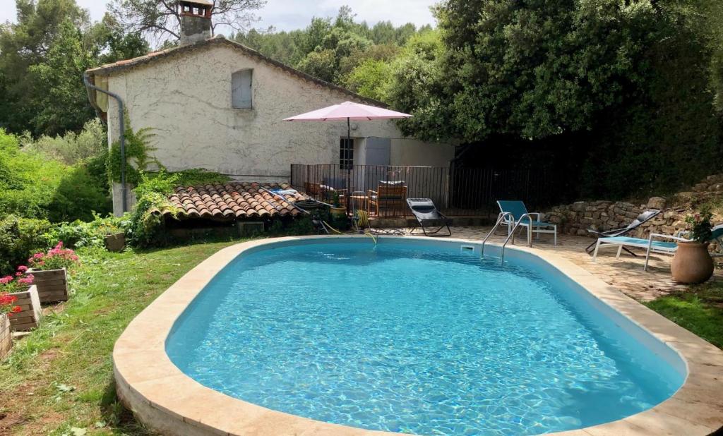 une piscine dans la cour d'une maison dans l'établissement Le mas du castellanet, à Taradeau
