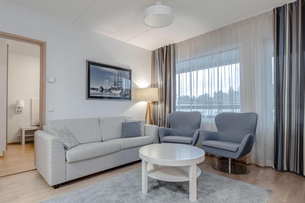 a living room with a couch and two chairs and a table at Holiday Club Caribia Superior Apartments in Turku