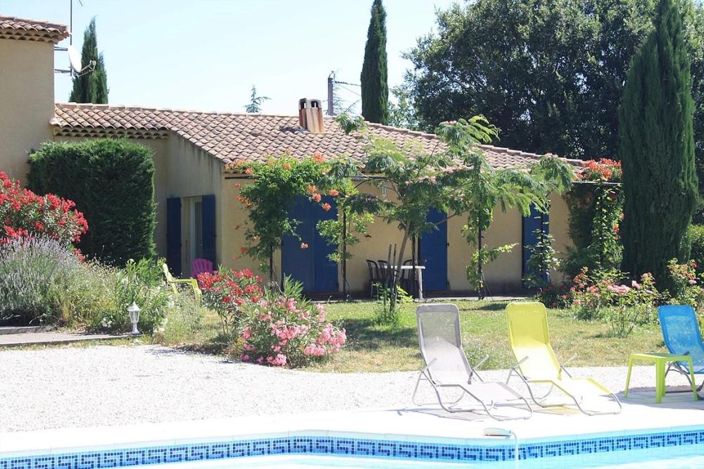 une maison avec deux chaises longues et une piscine dans l'établissement Les restanques, à Saint-Maximin-la-Sainte-Baume