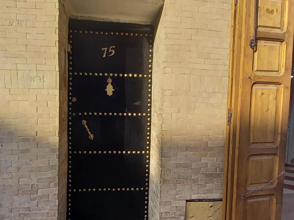 a black door with the number on it at Dar Rmila 4 in Marrakesh