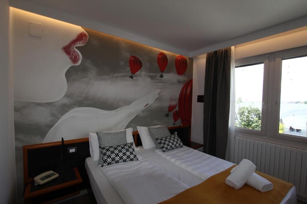 a bedroom with a bed with a picture of a woman at Hotel Belvedere in Venice-Lido