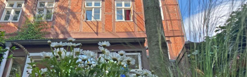 a brick building with white flowers in front of it at Frauenhotel Hanseatin - Women Only in Hamburg