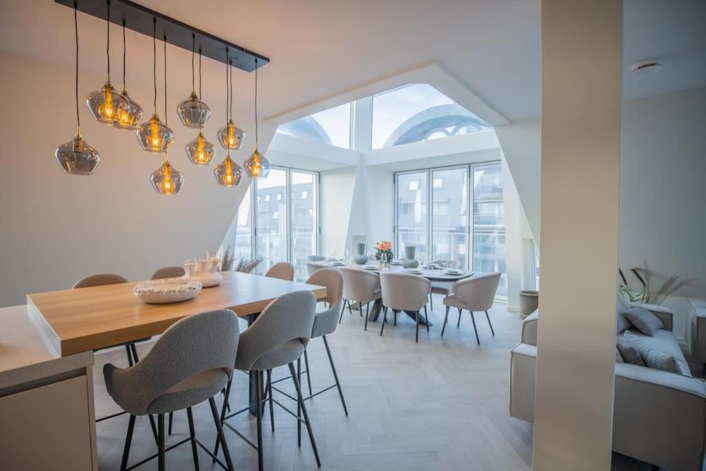 uma sala de jantar com mesa e cadeiras em Penthouse Royal, Luxurious and cozy with Sauna em Cadzand