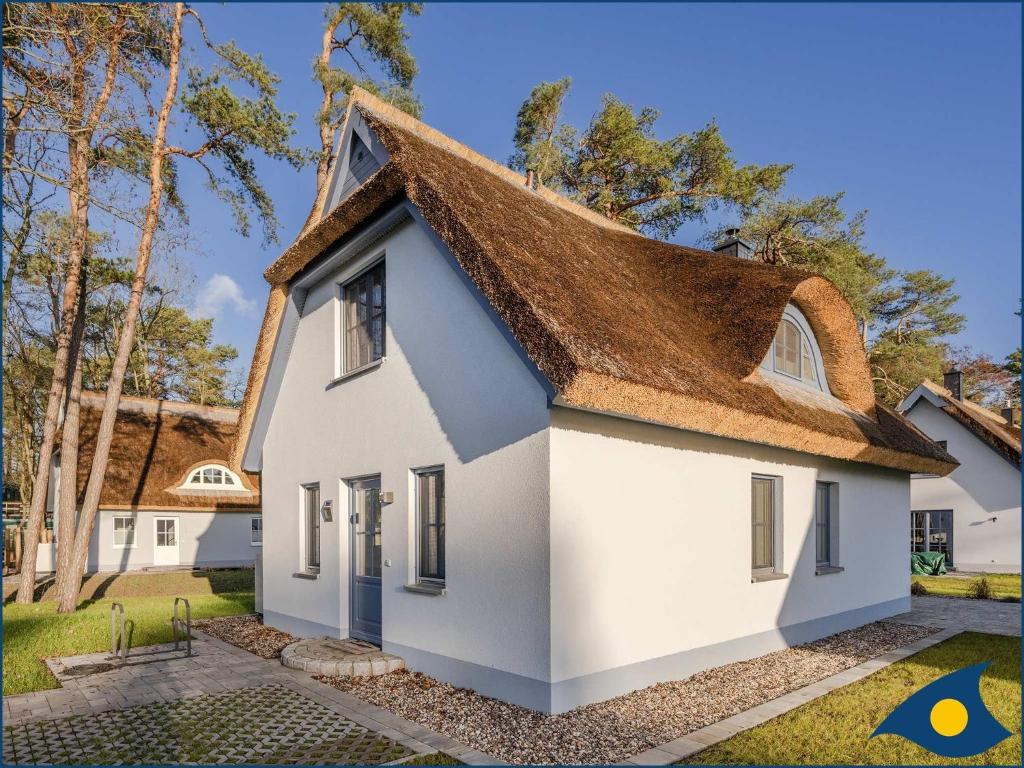 een wit huis met een rieten dak bij Fischerdorf Zirchow Zugvogel in Zirchow