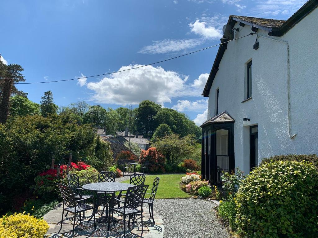 a table and chairs in a garden next to a building at Swallows House in Elterwater
