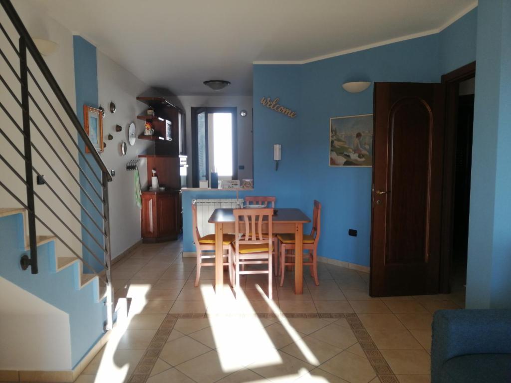 uma sala de jantar com paredes azuis e uma mesa e cadeiras em A casa di Rita em Surbo