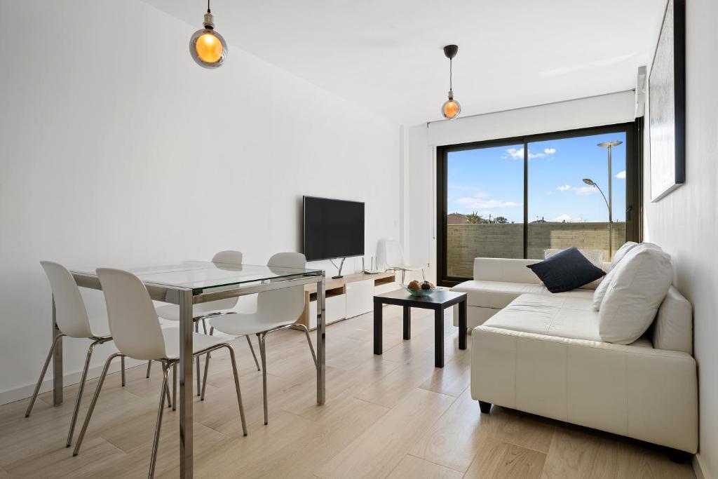 uma sala de estar branca com uma mesa e um sofá branco em Gregal by enjoy Rocas Doradas em L'Ametlla de Mar