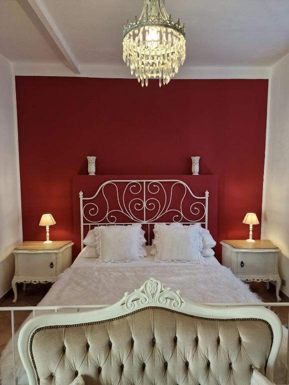 1 dormitorio con cama blanca y pared roja en Dragonfly Appartamento Bianca en Angera