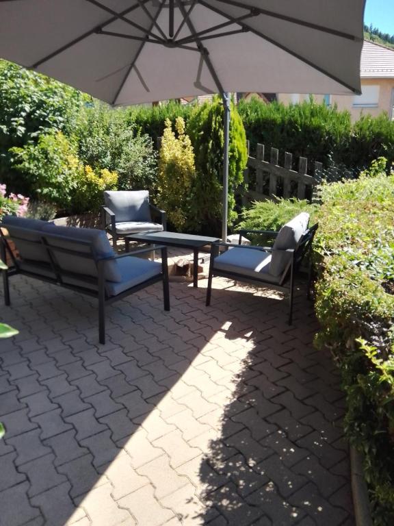 - une terrasse avec une table, 2 chaises et un parasol dans l'établissement Antilles, à Savines