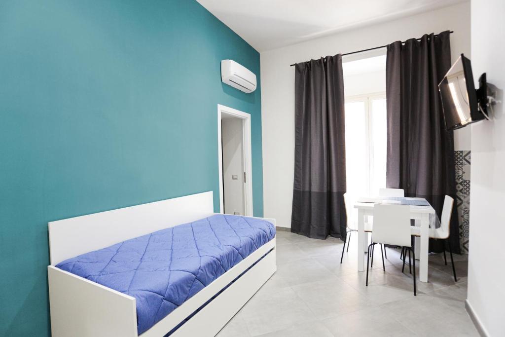 ein blau-weißes Schlafzimmer mit einem Bett und einem Tisch in der Unterkunft Duomo 34 Guest Room in Neapel
