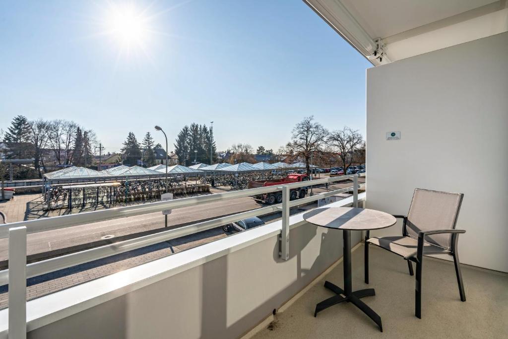 einen Tisch und Stühle auf einem Balkon mit Blick auf einen Ballpark in der Unterkunft Huber Living Basic 208 in Germering