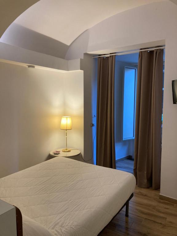 1 dormitorio con cama, lámpara y ventana en INTERNATIONAL GARIBALDI *, en Nápoles