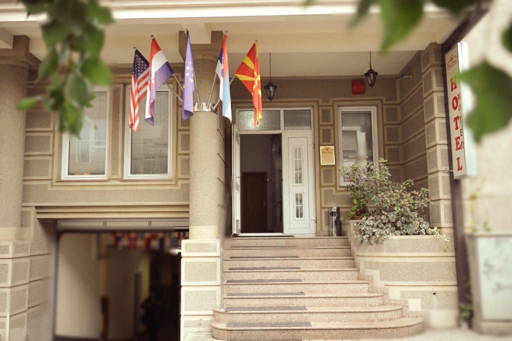un edificio con banderas en la parte delantera en Premier Hotel, en Skopje